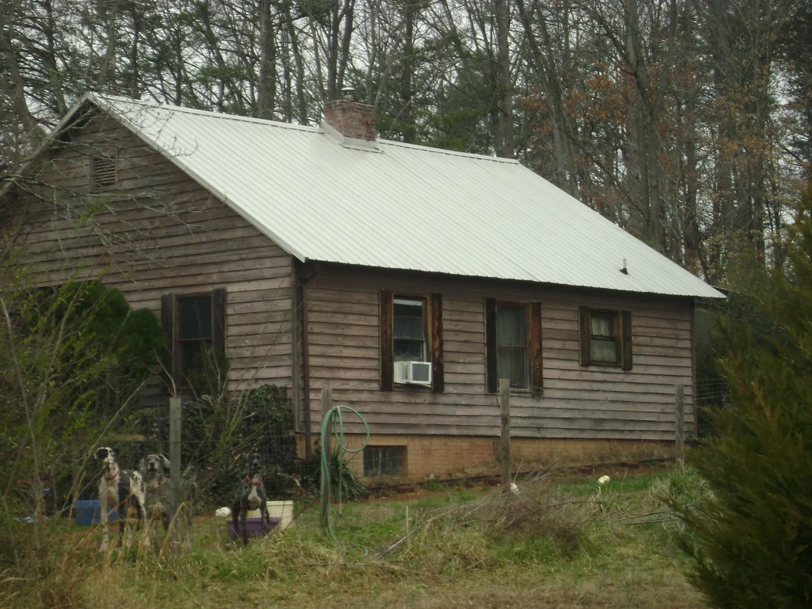 White metal roof on an old wood sided farmhouse, from a Metal Roof Installation job in Coats